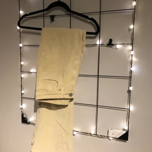 Ribbade utsvängda byxor  - Utsvängda byxor i ett ribbat material. Beige/gula i färgen. Passar storlek S.      