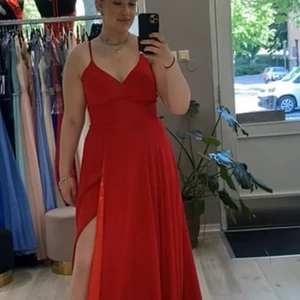 Balklänning  - Jag säljer nu min helt magiska balklänning, den är endast använd en kväll och i otroligt bra skick och kvalitet! Så otroligt fin röd färg och hög slits på ena benet! Älskar verkligen denna! Passar mig som är 176 cm lång och har cirka 42/44 perfekt!❤️ Kom med bud privat! Nypris 2499❤️