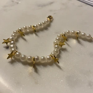 Armband - Armband med pärlor och guldiga stjärnor. Går att få i önskad längd. Även med silvriga stjärnor också.