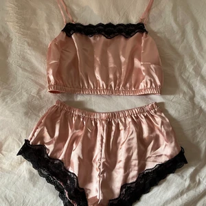 Ljusrosa satinpyjamas - Helt ny, aldrig använd rosa satin pyjamas med svarta spetsdetaljer! Supersöt och skön! Frakt 26kr🥰