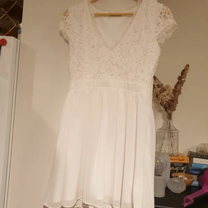 Vit klänning storlek 40 - Vit fin klänning med spets till överdelen. Dragkedja vid sidan och använd fåtal gånger. Storlek 40😊