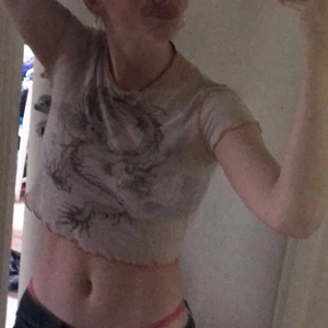 Croppad tröja med coolt tryck - En kort rätt genomskinlig t shirt med skitcoolt tryck. Vet in tre vilket märke men köpt secondhand. I bra skick