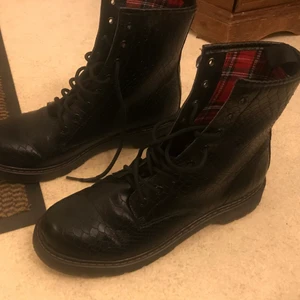 Svarta kängor  - Ett par svarta kängor i storlek 41 från Din sko, köpta för många år sedan men använts max 2 ggr. Lite ormskinns aktig struktur utanpå medan insidan har ett skottsrutigt tyg:)