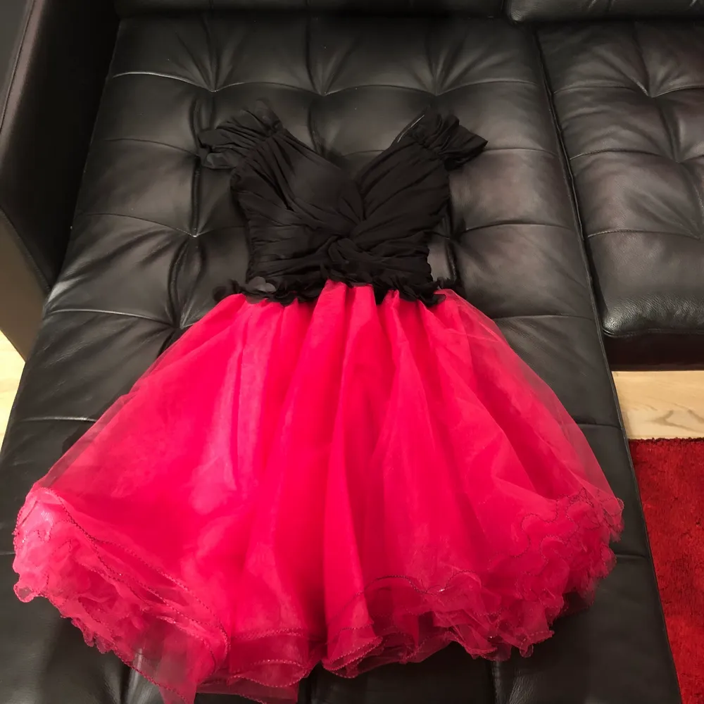 En jättefin klänning som jag hade på 1 gång till ett event men som är för liten för mig nu.                                   Färg: svart + fuchsia/ pink                                            OBS. Storlek: det står 38 i själva klänningen men pratar vi EUR storlekar, så motsvarar den till en 32/34 eller XXS/XS.                                                                    Med dragkedja på ryggen . Klänningar.