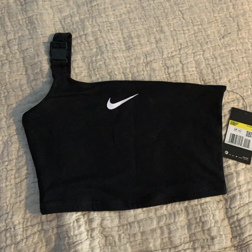 Nike croptop med en strap. Säljer då den aldrig kommit till användning! Aldrig använd och lappen finns kvar, alltså nyskick 😊 . Toppar.
