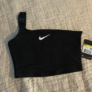Nike topp - Nike croptop med en strap. Säljer då den aldrig kommit till användning! Aldrig använd och lappen finns kvar, alltså nyskick 😊 