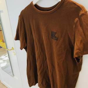 Brun T-shirt i tjockt texturerat tyg.