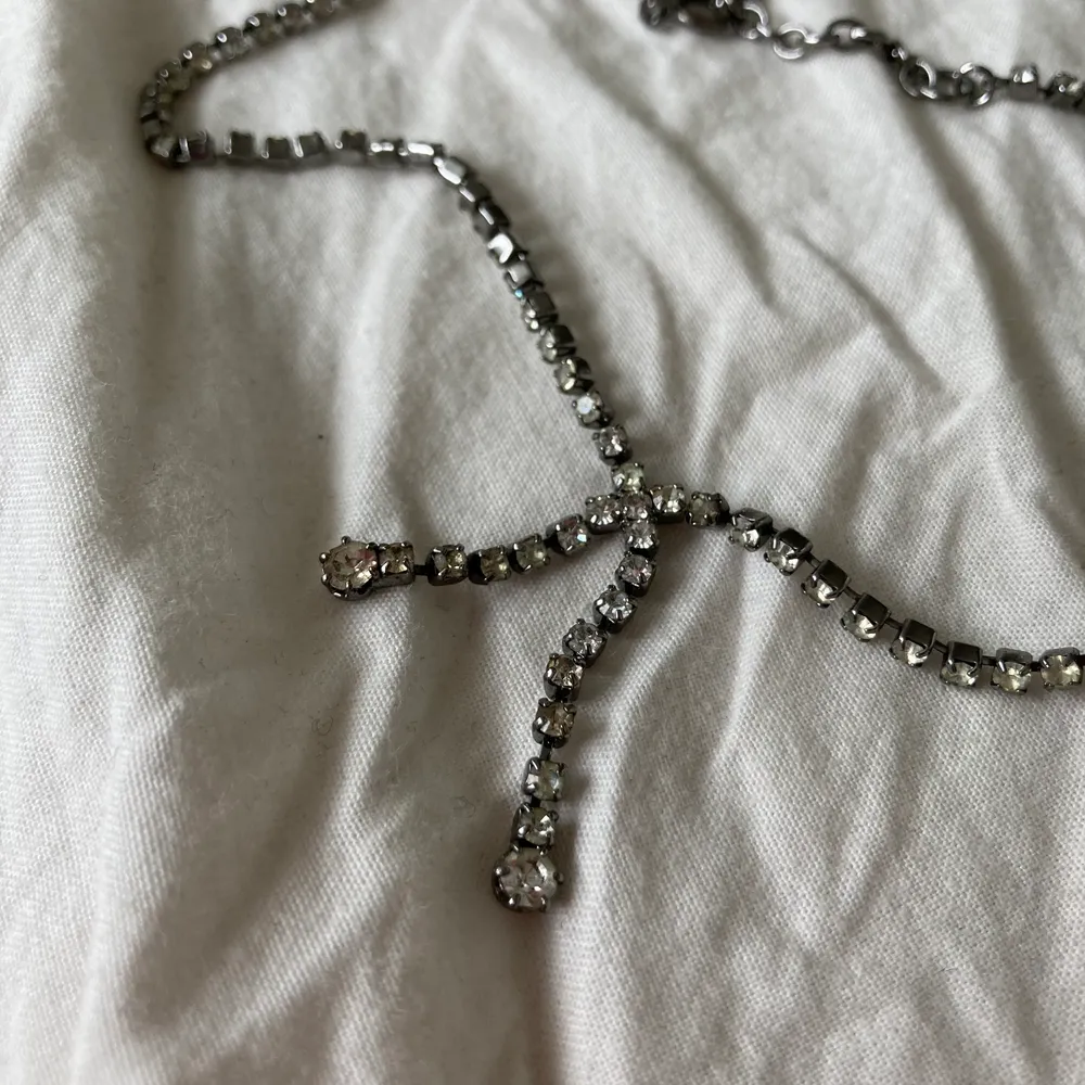 Nätt litet halsband med silvrig strass. ”Hänget” sitter fast i halsbandet. Justerbart. Oklart material. Fri frakt. Jag ansvarar inte för postens slarv.. Accessoarer.