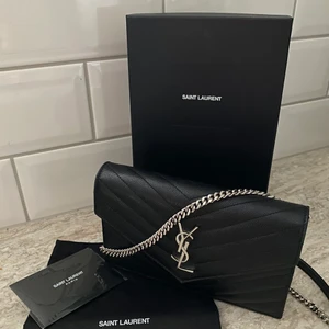 YSL wallet on chain - Säljer min YSL väska då den används för lite Sparsamt använd så i väldigt bra skick Köptes på Nathalie Schutterman december 2020 Höjd: 12,5cm Bredd: 19cm Djup: 3,5cm Box, dustbag och kvitto finns