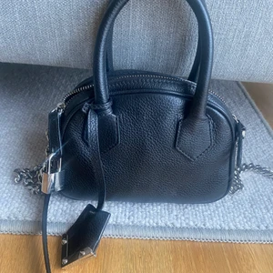 The Kooples väska - Säljer min the Kooples väska i svart läder med silvriga detaljer. As snygg! Köpt för ca 1 år sedan på the Kooples butik i Nice. Nypris 2990kr och använd sparsamt. Perfekt som vardagsväska då du får plats för allt du behöver: mobil, plånbok och mer! Skriv för fler bilder eller ev frågor 🌸💖 snygga nitdetaljer och ett justerbart axelband 🔥 har två öppna fickor samt ett fack med dragkedja inuti! 
