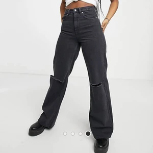 Gråa/svarta jeans - Ett par mörkgråa (?) Jeans från Asos/bershka med hål vid knäna och vida ben. Storlek 38. Köpta för 259kr och säljer nu för 120kr, köparen står för frakten. OBS!! Dragkedja har hoppat ut men tror de går att fixa om man e bra på alöjd osv, pris kan diskuteras eftersom de är lite svårt att dra i dragkedjan🤎