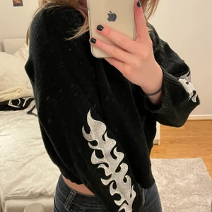 Stickad Tröja - Stickad tröja från Adika. Den har vita flammor på sidorna vilket ger en snygg detalj. Skön och mysig tröja för kallare väder!💕💕