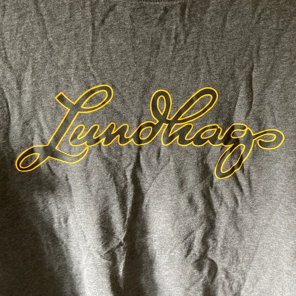 En grå t-shirt från Lundhags med gul text       I storlek S. T-shirts.