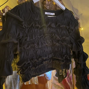 Svart festtopp - Festlig svart topp i lite glansigt material. Använd en gång.