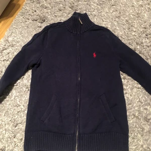 Ralph Lauren sport tröja - Säljer dennna jättefina stickade ziphoodien från Ralph Lauren då den inte är min stil riktigt. Den är som i nyskick utan några tecken på slitage. Den har en liten polo som man kan välja själv ska vara längre upp eller ner på halsen. Storleken är M, men skulle säga att man kan ha den även om man är S-M i storlek. Hör av er om ni vill ha fler bilder eller om det verkar intressant! Jag köpte den för 1100kr