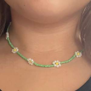 Pärl halsband men justerbart längd i bak.Färg grön gul vit 