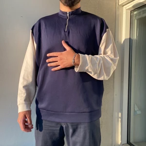 Blå/vit Sweatshirt XL - En blå sweatshirt med vita ärmar och zipup-krage. Tyget är väldigt svalt så den passar perfekt att rocka på sommarkvällar eller under en fet jacka till hösten!