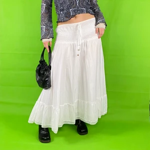 Kjol - Cottagecore och fairycore inspirerad långkjol i toppenskick! Från märket Ze-Ze, storlek M. Knytningen är för dekoration, så den kan inte knytas tajtare. Stretchigt runt höfterna/midjan. Kjolen har en underkjol. 100% cotton. Lite genomskinlig när den bärs som low wasited! Midja/höft bredd 45cm.  Längd 88cm. Spårbar frakt på 66kr är inräknad i priset. 