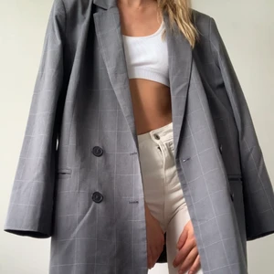 Kavaj Weekday  - En grå kavaj från Weekday med tunt subtilt rutigt mönster. Rätt tunn men faller supersnyggt och har lite axelvadd som gör siluetten perfekt. Strl 40 men sitter perfekt oversized på mig som är XS-S. FRAKT tillkommer från 66kr. 