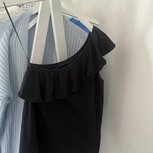 one shoulder top - jättefin svart one shoulde top med volang länsgt upp, från hm