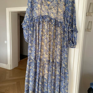 Midsommarklänning - blå med blommor - En fin långklänning perfekt till sommaren och midsommar. Endast använd vid två tillfällen. 