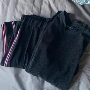 Glitter-set  - Säljer ihop-hörande set m vid byxa & tröja ifrån boohoo. Svartglittriga byxor m stripe på utsida ben & tröjan har liten krage + mudd vid ärmslut. Säljs pga den ej får den uppmärksamheten den borde! Plaggen kan va lite smånoppiga på vissa ställen men inget som störs :) skickas mot fraktpeng eller hämtas i Trollhättan. 
