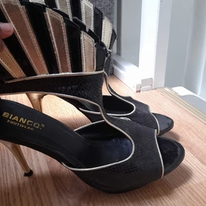 Festliga, dramatiska och höga guldklackar - Storlek 40, i kända märket Bianco footwear. Perfekt till just fest eller olika typer av sammankomst. 