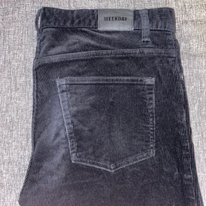 Weekday byxor stl.M - Svarta byxor i machestertyg från Weekday. Storlek 33, jag är 180 cm lång och bär vanligtvis M/L. Köpta från Zalando för 499:- i april 2020. Byxorna är använda fram tills för ett halvår sedan, tyget är i fint skick och inga fläckar eller hål. Skriv till mig vid frågor/fler bilder. Köparen står för frakt