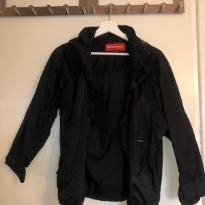 Svart regnjacka  - Svart regnjacka från Intersport. Knappt använd. Nypris 299 kr.