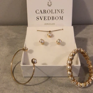Smyckeset Caroline Svedbom - Fint set från Caroline Svedbom, nytt i kartong med örhängen, halsband och två armband. Superfint till julfesten. Classic petit. Nypris 595 för armand 1, 995 för armband 2, örhängen 395, halsband 395. Säljes som helt kit. (Ca 2400 totalt i nypris).