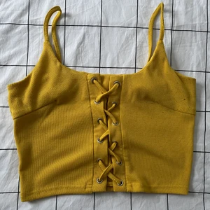 Topp - En croppad topp med snörning fram, ribbat material