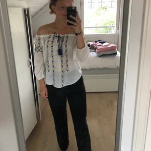 Vit Off-shoulder topp  - En vit, blå/gul off-shoulder topp från abecrombie & fitch. Tröjan är mycket stor i storleken och passar som en M. Den är använd väl och är i bra skick💕