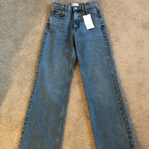 HELT OANVÄNDA ZARA JEANS - Säljer ett par helt oanvända ascoola och trendiga Zara jeans i storlek 34. Modellen heter ”Hi-rise full length” och är i en super fin blå färg som passar till allt. Säljs för de var försmå när jag fick dem.