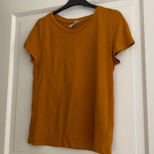 T-shirt  - Gul/orange T-shirt i mjukt tyg, knappt använt 