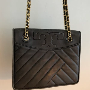 Tory Burch väska (svart) - Inköpt tory burch väska i New york, inköpt för 5000kr Använd endast  fåtal gånger! Kan även skickas med pälsbollen om så önskas! Kedjan går att reglera att ha bara över axeln eller längre kedja👍🏼