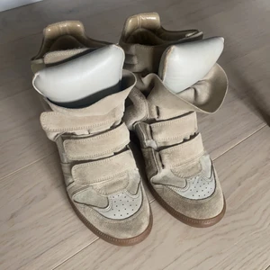 Isabel Marant skor, ”Bekett Sneakers” - Säljer mina Isabel Marant skor i färgen beige. Köpta av en kompis 2019, så har varken kvitto eller dustbag. Äktheten är dock kontrollerad på NK!!! Trots några år på nacken är de i väldigt bra skick utan några allvarliga slitage! Ska självklart putsa upp de innan de ges över till nästa ägare! Kan mötas upp i Stockholm, eller posta!