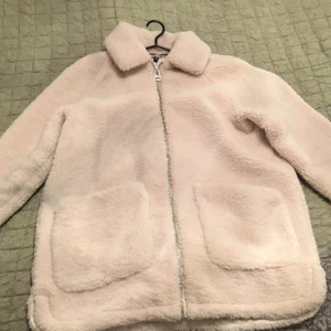 Beige pälsjacka st M - Beige pälsjacka i storlek M. Den är riktigt bra inför hösten. (fuskpäls)