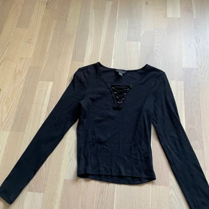 Långärmad svart tröja - Långärmad svart tröja med snörning fram. Storlek 40