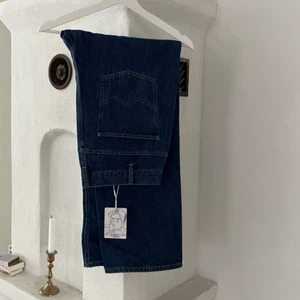 MCMXCIII jeans storlek L - Ett par mörka jeans i storlek L i snygg boxy fit lägger sig väldigt snyggt över skorna! Prislappen sitter kvar så de är nya