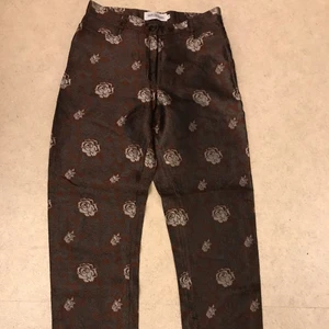 Finbyxor - Ett par brunmönstrade byxor i tunt lite glansigt tyg. Den är i storlek 40 men en liten en, samt ingen stretch!