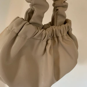 Beige/ljusbrun axelväska - Liten beige handväska i fejk läder från NAKD. 