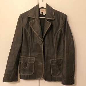 Mörkbrun vintage skinnkavaj  - Säljer min absoluta favorit skinnkavaj då jag tyvärr tycker den sitter lite för litet på mig:( hade velat ha den lite större, skulle säga att den är perfekt på en XS eller S (jag brukar ha M-L i jackor). Den är ifrån OBJECT, köpt vintage. Lite gråbrun i färgen med ljusare kanter. Ett coolt tryck på ena sidan av ryggen också