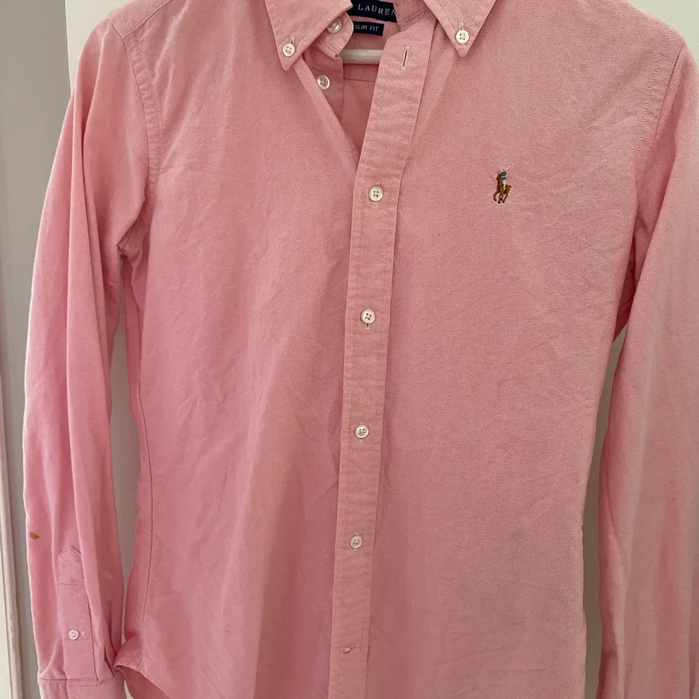 Ralph Lauren dam skjorta i rosa färg. Super slim fit i storlek 6, vilket motsvarar xs/small . Liten färg fläck på armen. Ord pris 1200 kr. Skjortor.