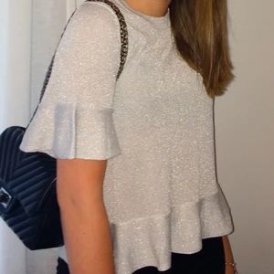 GLITTRIG TOPP - Glittrig, finstickad topp med volanger från H&M. Superfin både till vardag & på fest. Strl S. Knappt använd💕💕💕