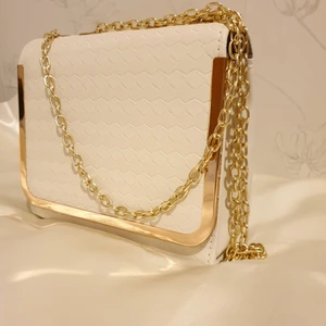 Krämvit väska med guldkedja - 💛FÖRST TILL KVARN!💛 En krämvit väska med ett unikt hexagon tryck på lädret. Har en guldkedja i två längder & är I jättefint skick. Rensar garderoben så vill bli av med ASAP! Pris: 65+ frakt