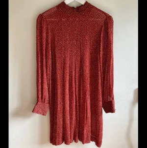 Röd klänning med fin knäppning i rygg  - Fin klänning från indiska, långa ärmar. Kjoldelen går till knäna på mig ungefär (163 lång) 