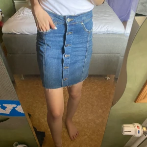Gina Tricot jeanskjol strl 34 - Mörkblå jeanskjol från Gina Tricot i storlek 34. Lite slitningar vid fickorna, kjolen är gjord så. Bara testad ett fåtal gånger. 
