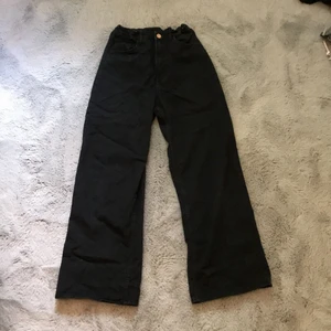 Svarta vida jeans - Ett par svarta vida jeans med brons knapp. Fickor både fram och bak, resår i midjan. Använt ganska mycket, men inte överdrivet. Inga tecken på använd.