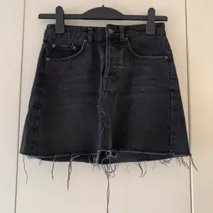 Svart/Grå jeanskjol från Gina tricot i storlek 34. Skulle säga att även denna kjol skulle passa en 36 väldigt bra. Fint skick och ej använd speciellt många gånger. 