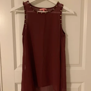 Vinrött linne med detaljer - Fint vinrött linne med detaljer på sidan! 20kr+frakt 